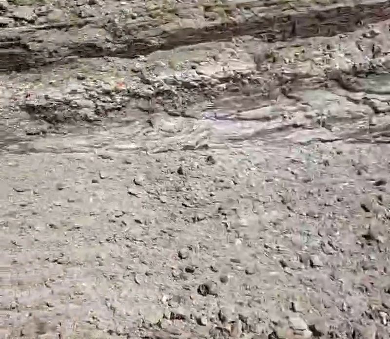 Fondo de la excavación de una piscina de obra con terreno de roca y piedra suelta